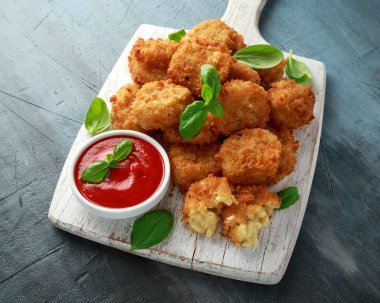 Kızarmış Mac, makarna ve peynir ısırıkları, Beyaz ahşap tahta üzerinde ketçap soslu ekmek kırıntıları