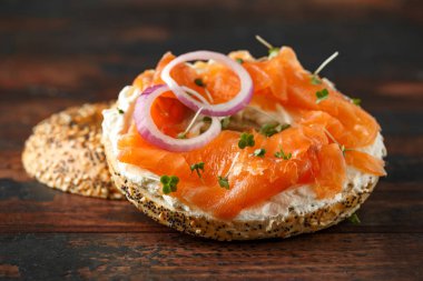 Ahşap masa üzerinde Krem peynir ve somon ile Bagels kahvaltı sandviç