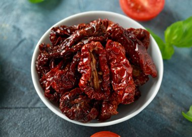 Domates ve fesleğen ile beyaz kapta güneşte kurutulmuş domates