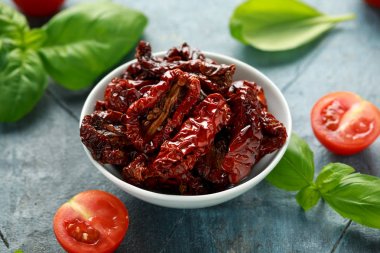 Domates ve fesleğen ile beyaz kapta güneşte kurutulmuş domates