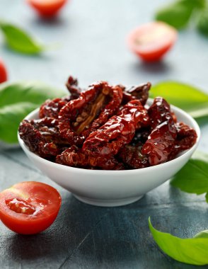 Domates ve fesleğen ile beyaz kapta güneşte kurutulmuş domates