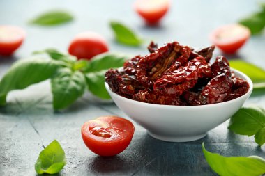 Domates ve fesleğen ile beyaz kapta güneşte kurutulmuş domates