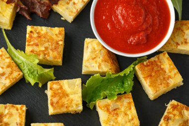 Taş tahta üzerinde domates soslu İspanyol Patates Frittata tapas