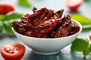 Domates ve fesleğen ile beyaz kapta güneşte kurutulmuş domates