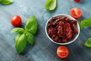 Domates ve fesleğen ile beyaz kapta güneşte kurutulmuş domates