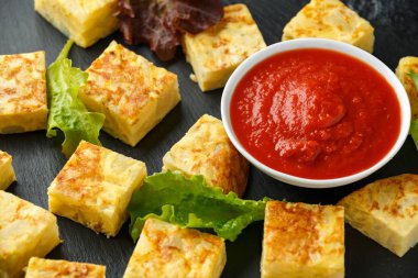 Taş tahta üzerinde domates soslu İspanyol Patates Frittata tapas