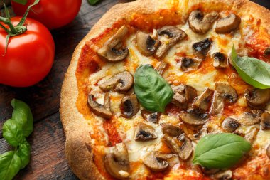 Ahşap masada fesleğen, domates, mozzarella ve parmesan peyniri ile Sıcak Mantar Pizza. yemeye hazır. vejetaryen gıda