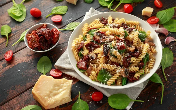 Фусілі Паста з сушеними помідорами, грибами, пармезановим сиром та шпинатом. здорова їжа . — стокове фото