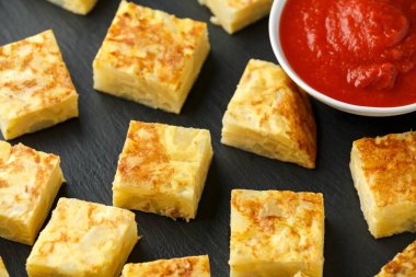 Taş tahta üzerinde domates soslu İspanyol Patates Frittata tapas