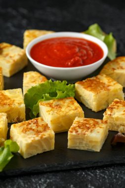 Taş tahta üzerinde domates soslu İspanyol Patates Frittata tapas