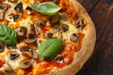 Ahşap masada fesleğen, domates, mozzarella ve parmesan peyniri ile Sıcak Mantar Pizza. yemeye hazır. vejetaryen gıda