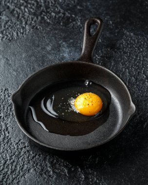 Baharat ile Yumurta dökme demir tavada pişirmeiçin hazır, tavada kızartma