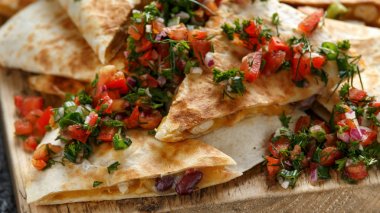 Tavuk ve peynir ile Meksika gıda quesadillas ev yapımı taze salsa tepesi ile rustik ahşap doğrama tahtası servis
