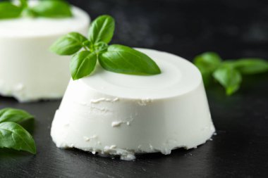 Siyah rustik masada fesleğen yaprağı ile taze Ricotta peyniri. seçilen odak