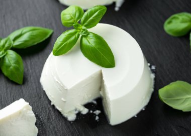 Siyah rustik masada fesleğen yaprağı ile taze Ricotta peyniri. seçilen odak