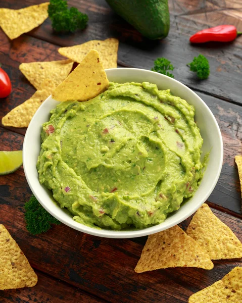 Skål med färsk guacamole med nachos chips och örter. Hälsosam vegan, grönsaker mat. — Stockfoto