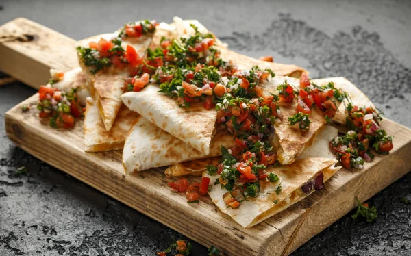 Tavuk ve peynir ile Meksika gıda quesadillas ev yapımı taze salsa tepesi ile rustik ahşap doğrama tahtası servis