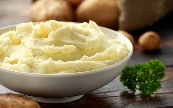 Purê de batatas em tigela branca na mesa rústica de madeira. Alimentos saudáveis — Fotografia de Stock