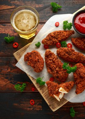 Ahşap tahta üzerinde bira, ketçap ve mayonez ile Ekmekli tavuk şeritler