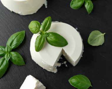 Siyah rustik masada fesleğen yaprağı ile taze Ricotta peyniri