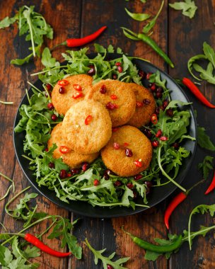 Tayland gıda baharatlı balık kek nar tohumu ve yabani roket, arugula salata ile servis.