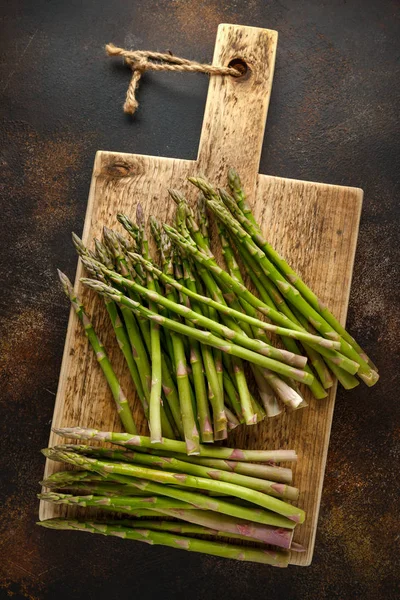 Freshly picked organic asparagus on wooden board — Stock Photo, Image