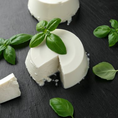 Siyah rustik masada fesleğen yaprağı ile taze Ricotta peyniri