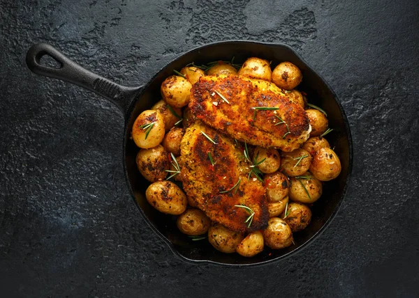 Pollo recién cocido y empanado Kievs servido con patatas crujientes al horno de romero en sartén rústica de hierro fundido, sartén — Foto de Stock