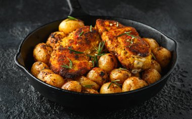 Taze pişmiş ekmekli tavuk Kievs rustik dökme demir tavada gevrek pişmiş biberiye patates ile servis, tava