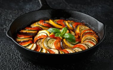 Kabak, patlıcan, domates, sarımsak, soğan ve fesleğen ile Ratatouille Sebze Güveç. dökme demir tavada. Geleneksel Fransız yemekleri.