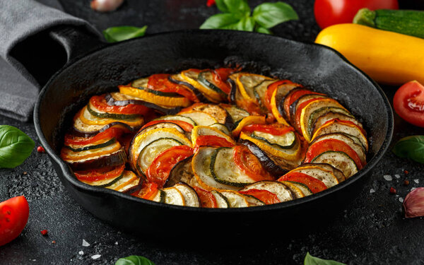 Ratatouille Vegetable Stew with zucchini, eggplants, tomatoes, garlic, onion and basil. on cast iron pan. Traditional French food.