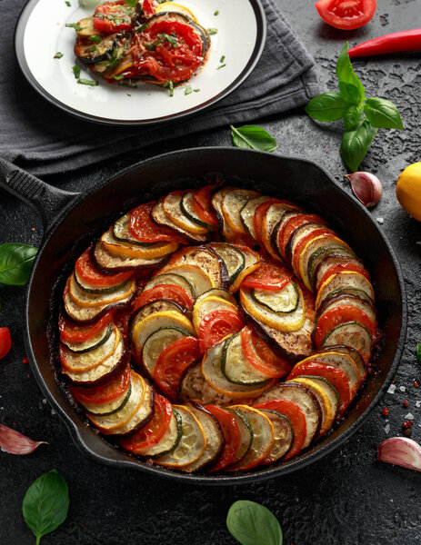 Ratatouille Vegetable Stew with zucchini, eggplants, tomatoes, garlic, onion and basil. on cast iron pan. Traditional French food.
