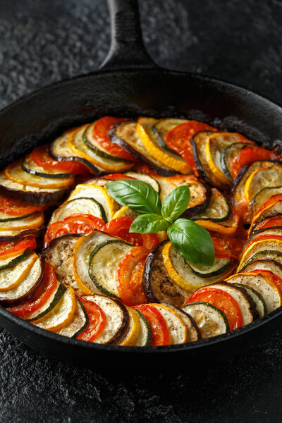 Ratatouille Vegetable Stew with zucchini, eggplants, tomatoes, garlic, onion and basil. on cast iron pan. Traditional French food.