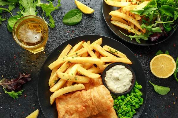 British traditionell fisk och chips med ärtor, tandsten sås och kall öl. — Stockfoto