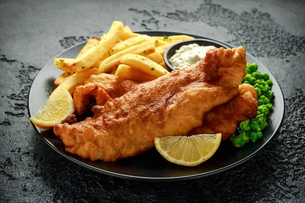 British traditionell fisk och chips med ärtor, tandsten sås och kall öl. — Stockfoto