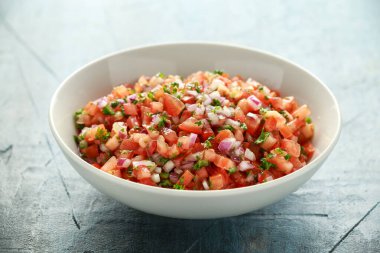 Limon, kırmızı soğan, jalapeno biber, maydanoz ve tortilla cips ile beyaz kapta Meksika Domates Salsa