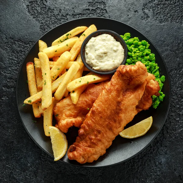 Peixe tradicional britânico e batatas fritas com purê de ervilhas, molho tártaro e cerveja gelada . — Fotografia de Stock