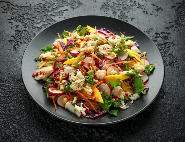 Krabbensalat mit Gemüse, Rettich, Karotten, Mango, Pinienkernen und Krabbencrackern — Stockfoto