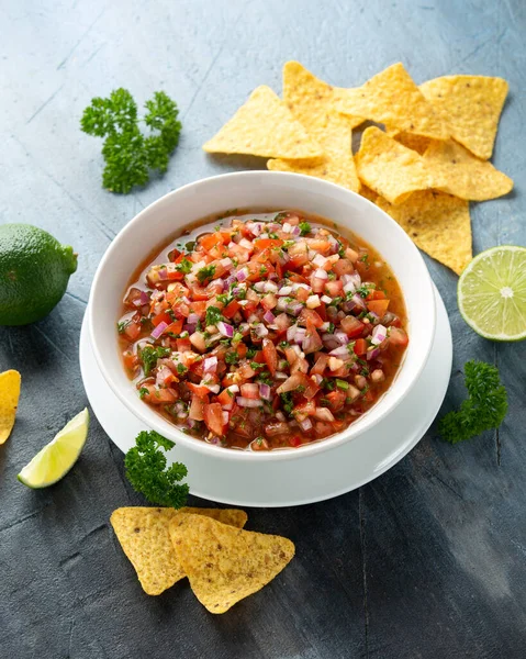 Meksykańska pomidor Salsa w białej misce z wapna, czerwona cebula, papryka jalapeno, pietruszka i chipsy tortilla — Zdjęcie stockowe