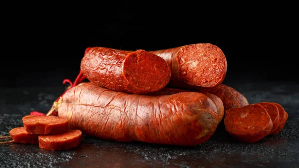 Traditionelle balearische Rohwurst Sobrassada aus Schweinefleisch, Paprika und Gewürzen auf rustikalem schwarzem Hintergrund — Stockfoto