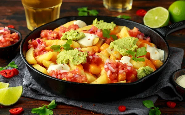 Loaded potato nachos with melted cheddar cheese, sour cream, tomato salsa, chilli, guacamole and beer