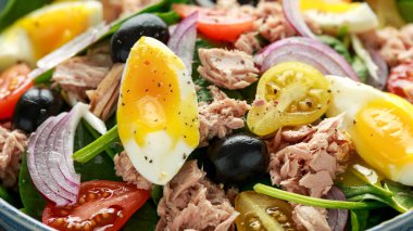 Protein paketlenmiş ton balığı ve armut şeklinde domates, siyah zeytin ve ıspanaklı yumuşak yumurta salatası.