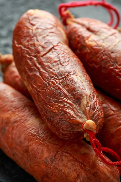 traditional Balearic raw cured meat sobrassada sausage made from ground pork, paprika and spices on rustic black background