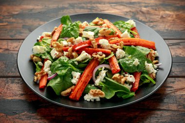 Peynirli kızarmış havuç salatası, ceviz ve ıspanak. sağlıklı yiyecekler