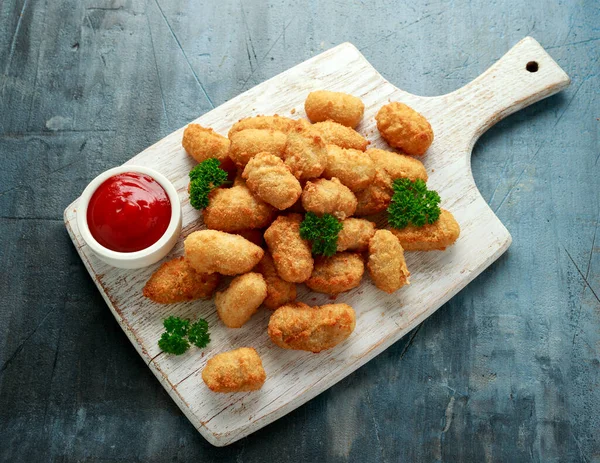 Nuggets crocantes de scampi com ketchup na tábua de madeira branca — Fotografia de Stock