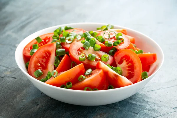 Rajčatový salát s jarní cibulí a bylinkami v bílé míse. Zdravé letní jídlo — Stock fotografie