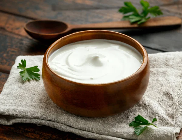 Griekse yoghurt in kom op rustieke houten tafel — Stockfoto