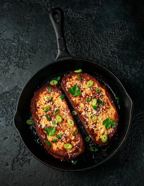 Queso parmesano tostada francesa con cebolla primaveral en sartén de hierro fundido — Foto de Stock