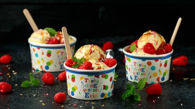 Ahududu meyvesi ve karamel soslu kağıt bardakta dondurma.