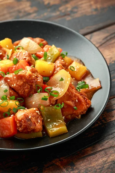 Piña y pollo en salsa agridulce con pimiento, arroz y cebolla de primavera en plato negro — Foto de Stock